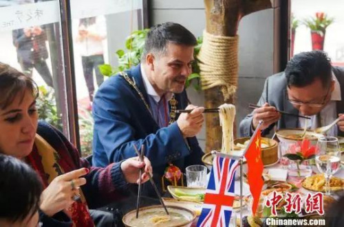 　资料图：2016年1月13日，英国市长访华代表团在柳州市品尝螺蛳粉。　黄威铭 摄