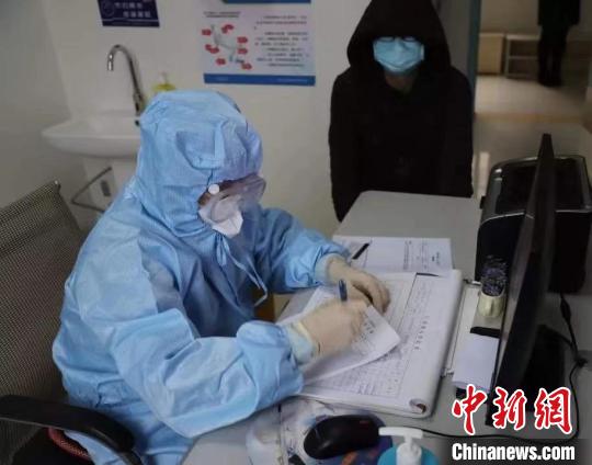 图为张永宏(左一)在枣阳市第一人民医院发热门诊为病人看诊。　受访者供图 摄