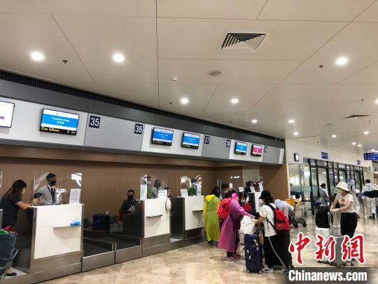 中国侨网5月7日下午2:50，南方航空CZ3092航班载着264名滞留菲律宾同胞从马尼拉国际机场起飞，5:04安全降落广州白云国际机场。图为同胞在“新常态”防护设置的马尼拉机场办理登机手续。　何乐（通讯员）　摄