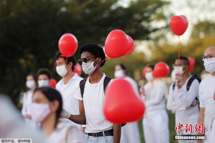 当地时间6月1日，巴西首都巴西利亚，艺术家们手持红色气球悼念在新冠肺炎疫情中不幸离世的人们。