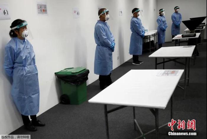 资料图：新加坡樟宜展览中心“方舱医院”。图为医护人员在穿好防护服等待病人。