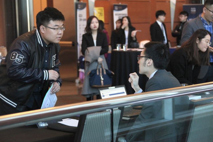 2019年4月28日，由欧美同学会加拿大之友会主办的2019中国留学生春季招聘会在大多伦多地区万锦市（Markham）举行。图为求职留学生（左）在现场与一家雇主单位代表沟通、交流。 （图片来源：中新社）