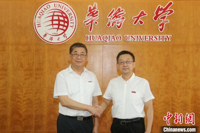 卸任党委书记关一凡(左)与新任党委书记徐西鹏亲切握手。　张彬 摄