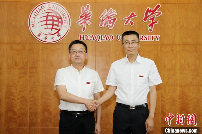 华侨大学新任党委书记徐西鹏(左)与新任校长吴剑平亲切握手。　张彬 摄