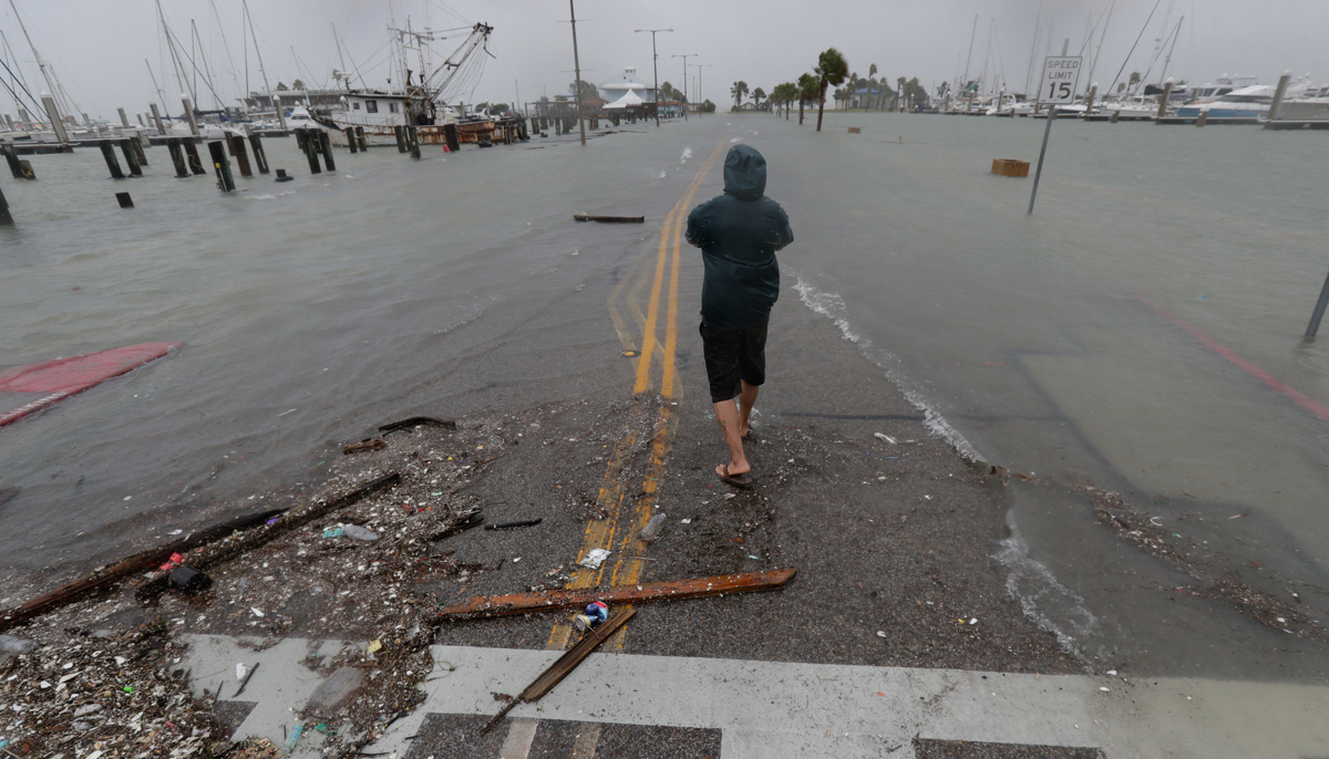 “汉娜”登陆科珀斯克里斯蒂后部分道路被洪水淹没，一男子正在拍摄照片。