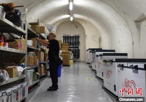 中国侨网图为火锅店老板在防空洞改造的库房里整理货物。　周毅　摄