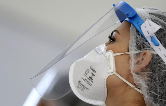 8月24日，在巴西首都巴西利亚，医务人员佩戴口罩和防护面罩为一家超市的员工进行新冠病毒检测。新华社 图