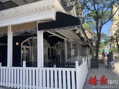 中国侨网一家曼哈顿餐厅使用塑料布隔离相近的餐桌。(美国《侨报》/刘依玲 摄)