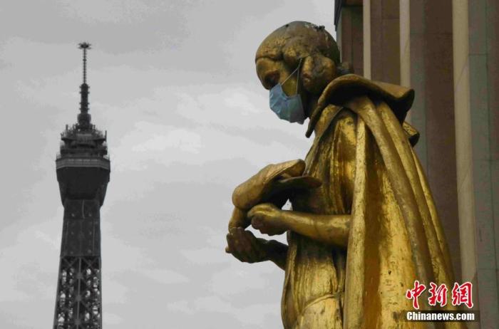 当地时间5月8日“欧洲胜利日”拍摄的雕塑，背景为埃菲尔铁塔。法国将于5月11日起逐步“解封”，为了提醒民众“解封”后注意防护，巴黎著名景点夏洛宫外的金色雕塑被戴上了口罩。<a target='_blank'  data-cke-saved-href='http://www.chinanews.com/' href='http://www.chinanews.com/'>中新社</a>记者 李洋 摄