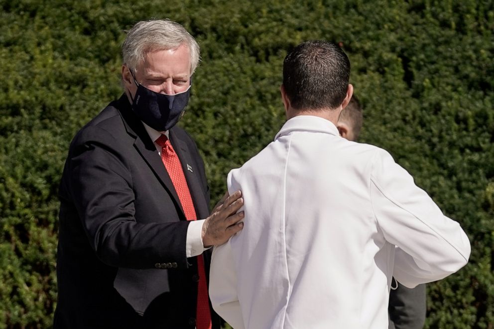 PHOTO: White House chief of staff Mark Meadows pats U.S. Navy Cmdr. Dr. Sean Conley, the White House physician, on the back following a media briefing about President Donald Trump's health in Bethesda, Md., Oct. 3, 2020.