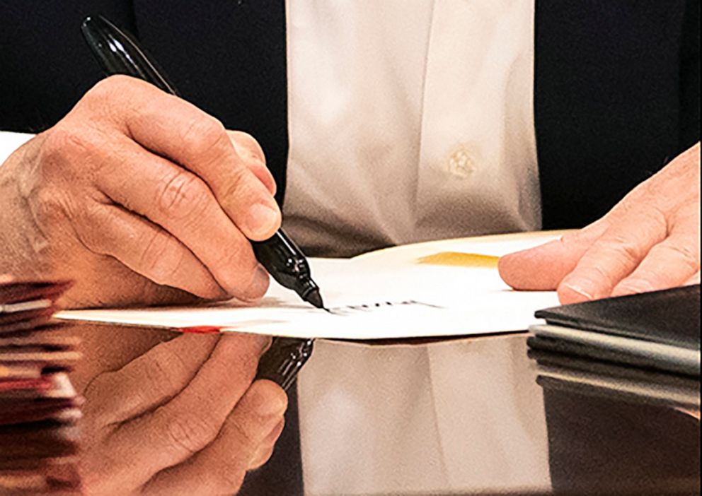 PHOTO: In a detail from a photo released by the White House, President Donald Trump's hands are seen as he writes on a piece of paper in the Presidential Suite at Walter Reed National Military Medical Center in Bethesda, Md., Oct. 3, 2020.