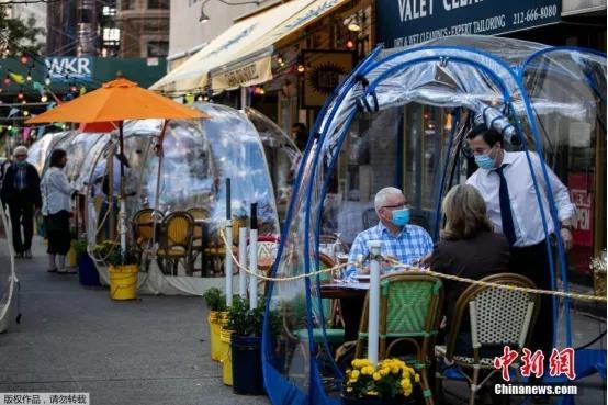 资料图：当地时间9月23日，美国纽约市曼哈顿区一家商铺推出“泡泡帐篷”以增加顾客之间的社交距离。
