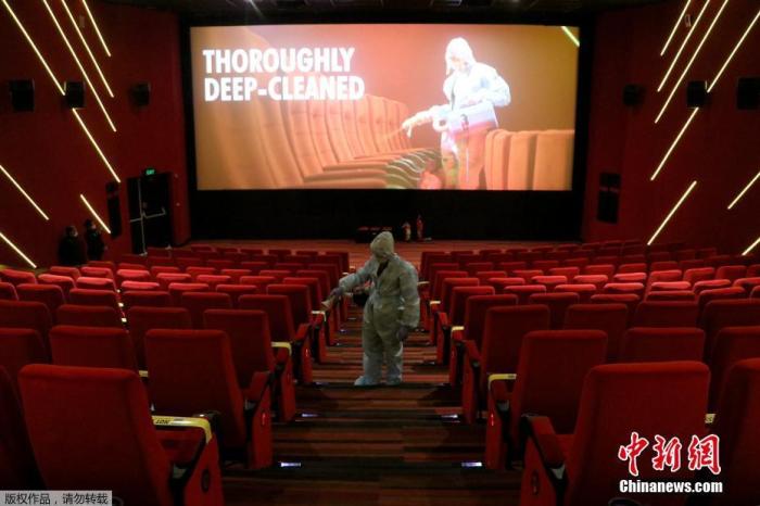 当地时间10月13日，印度孟买，一名穿着个人防护设备的工人在Inox Leisure电影院重新开放前为座椅消毒。