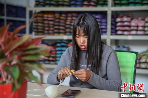 中国侨网图为一位员工在制作毛线拖鞋配件。　瞿宏伦　摄