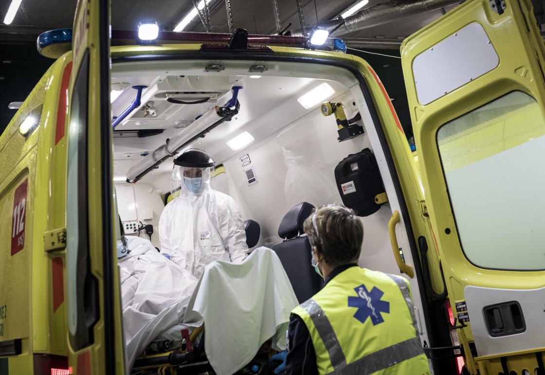 10月29日，在比利时列日，身着防护服的急救人员将患者运抵医院。新华社 图