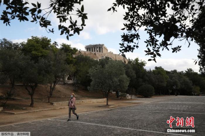 资料图：当地时间11月7日，希腊雅典，一名戴口罩女子经过帕特农神庙。