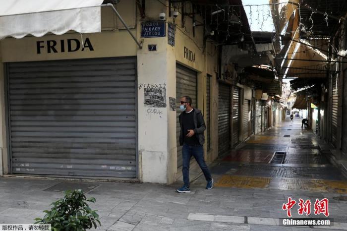 当地时间11月7日，希腊雅典，行人经过关闭的商业街。