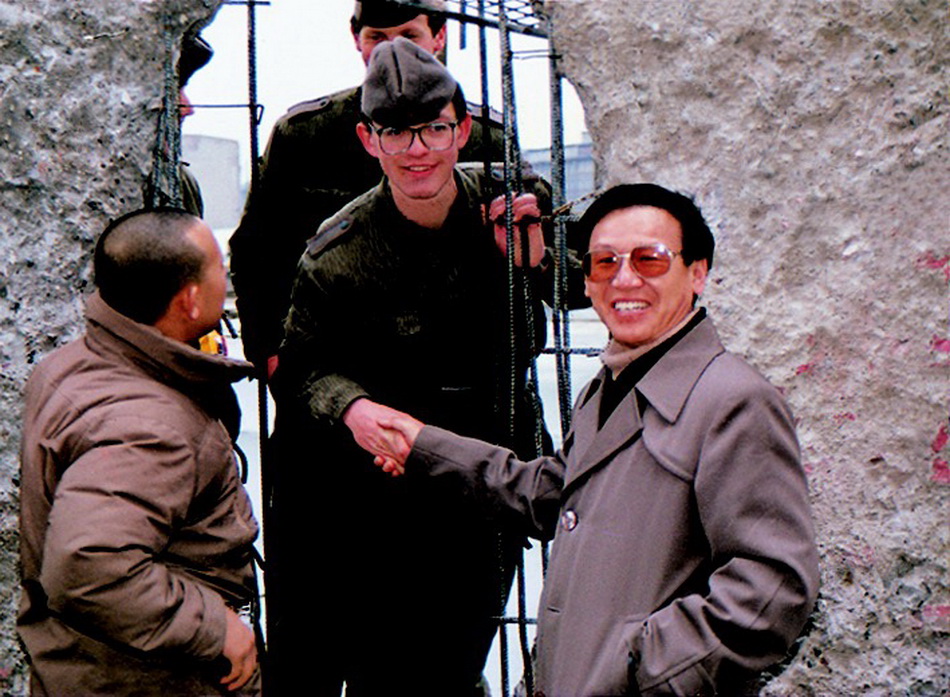 1990年，柏林国际电影节期间。谢飞、姜文在柏林墙，透过凿开的墙体和东德士兵握手、聊天。本文资料图来自海南出版社《谢飞电影艺术文集》（暂定名）