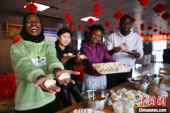图为留学生开心展示包好的饺子。　翟羽佳 摄