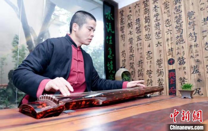 图为阮延俊正在弹奏古琴 张畅 摄 图为阮延俊正在弹奏古琴 张畅 摄