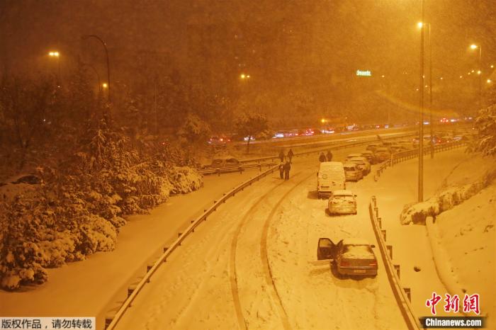 2021年1月9日，西班牙马德里，人们在大雪中把车停在高速公路上。
