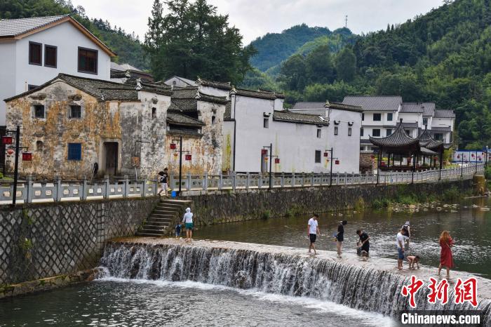 杭州临安龙门秘境，村民与游客在溪水中嬉戏。　范宇斌 摄