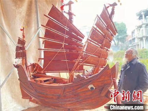 中国侨网毛祖先站在造好的木船前细细地看，就像看着心爱的孩子。　章海英　摄