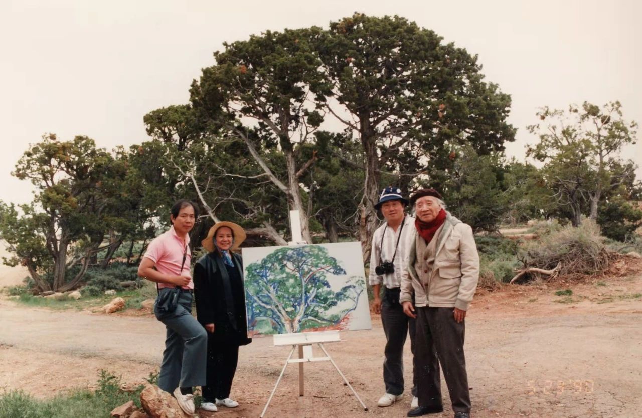 1990年5月23日，刘海粟在大峡谷写生作第二幅油画《古柏》。图为在古柏前与完成的油画作品合影（从右到左：刘海粟、张善利、 夏伊乔、吴正光）。