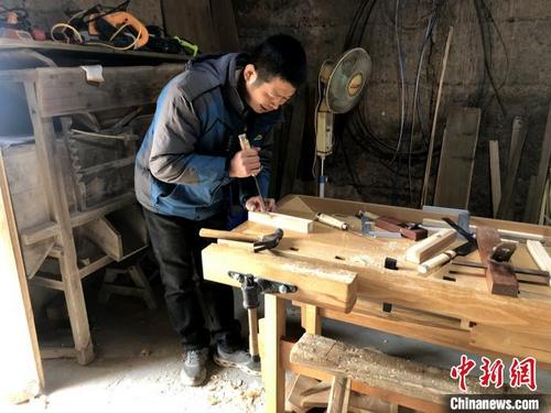 中国侨网吴清贵正在制作凳腿。　郭玲　摄