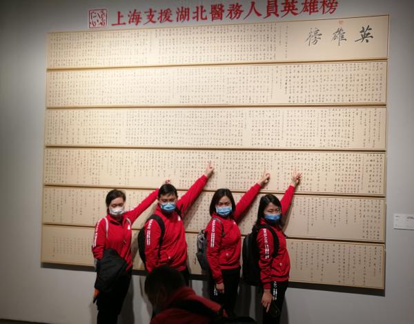 “召唤——上海市抗击新冠肺炎疫情美术、摄影主题展”上，上海援鄂医疗队成员在书法《上海支援湖北医务人员英雄榜》中指着自己的名字