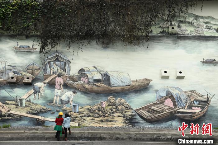 图为重庆街头的巨型涂鸦墙吸引市民驻足参观。　周毅 摄