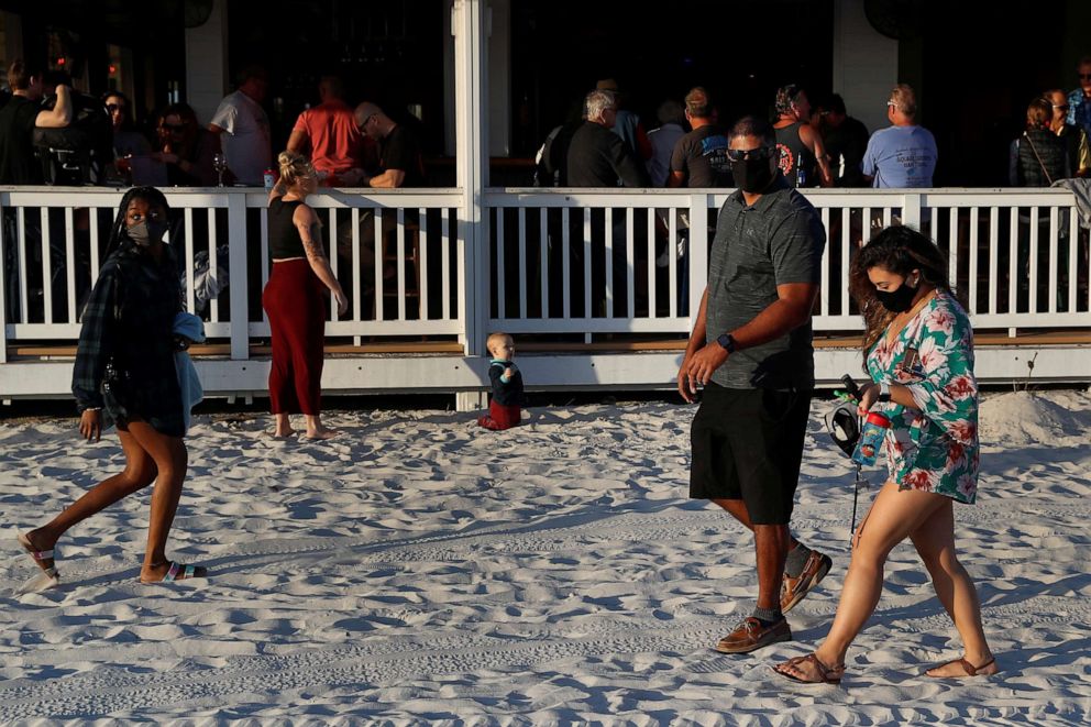 PHOTO: People walk on the sand amid the spread of the coronavirus disease, outside a restaurant in Clearwater Beach, Fla., Jan. 31, 2021.