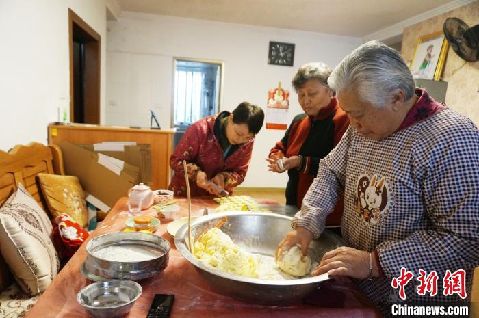 2月1日，78岁的印尼归侨张停娘(右一)与家人和朋友，在家里制作印尼菊花饼。　欧惠兰 摄