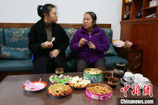 中国侨网图为60岁印尼归侨陈兆钿女士(右)与朋友分享印尼风味九层糕、千层蛋糕、蛋白糕、菊花饼和印尼麻花。　欧惠兰　摄