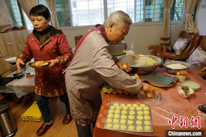 2月1日，78岁的印尼归侨张停娘(右)与女儿，在家里制作印尼菊花饼。　欧惠兰 摄
