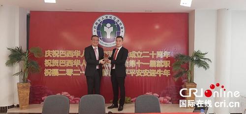 中国侨网新任文协主席上官建峰（左）与前任主席程普（右）进行换届交接