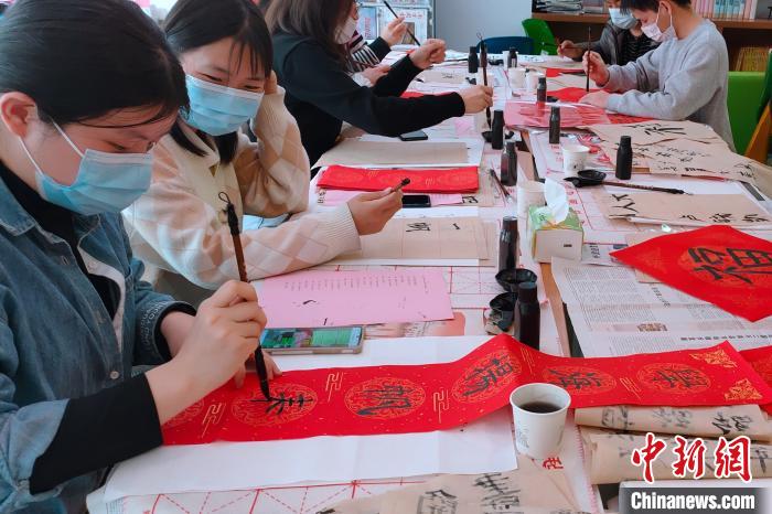留校过年的学生写春联、写福字,装扮校园、增添年味。 刘沛 摄 留校过年的学生写春联、写福字,装扮校园、增添年味。 刘沛 摄
