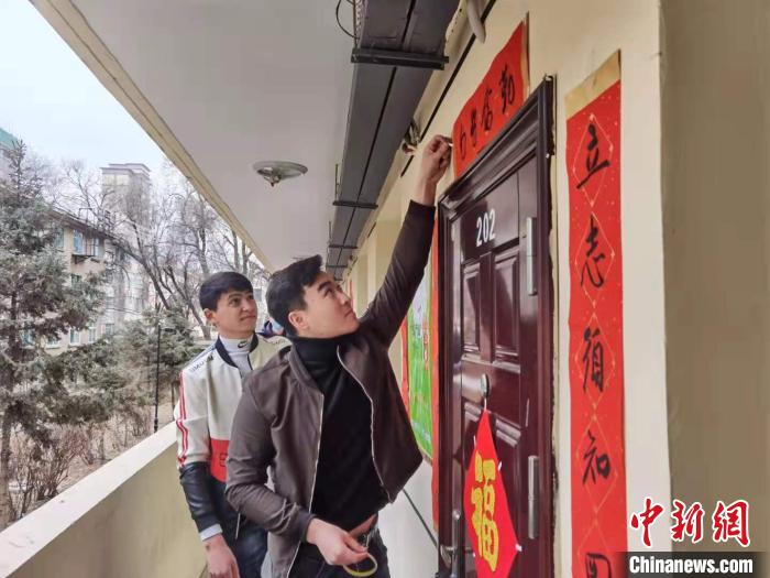 图为青海民族大学留学生在宿舍门口贴春联。 潘雨洁 摄 图为青海民族大学留学生在宿舍门口贴春联。 潘雨洁 摄