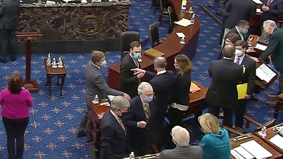 PHOTO: Senate Minority Leader Mitch McConnell and other Republican senators and staff talk on the floor after a vote on the motion to allow witnesses in the second impeachment trial of former President Donald Trump in the Senate. Feb. 13, 2021.