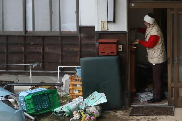 2月15日，在日本福岛县二本松市，迟耒收拾家门口的物品。新华社记者 杜潇逸 摄