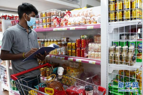2月13日，斯里兰卡科伦坡一家中国超市，一名当地雇员根据顾客通过小程序定制的购物清单备货。新华社记者 唐璐 摄