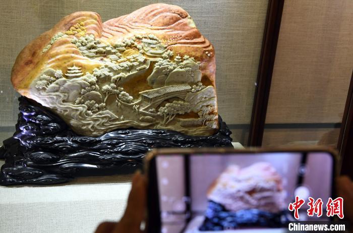 展出的中国工艺美术大师陈礼忠寿山石雕精品《下党新貌》，吸引观众观看。　记者刘可耕 摄