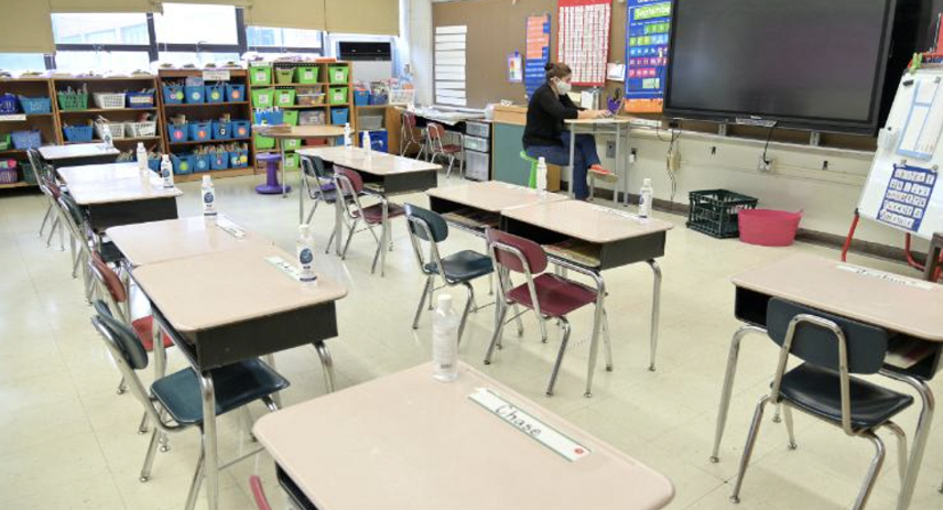 美国一学校教室通过分隔课桌的方式 让学生维持社交距离。