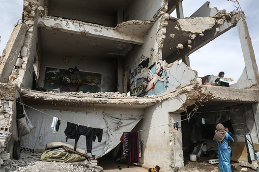 2020年4月伊德利卜省，一名流离失所的叙利亚妇女带着两个孩子找了一处濒临倒塌的危房生活。本文图片 央视新闻