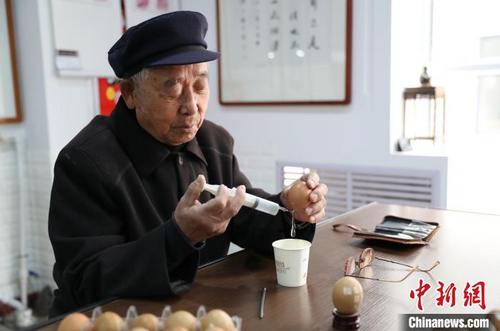 中国侨网宋福善正在用针管吸取蛋液。　于晶　摄