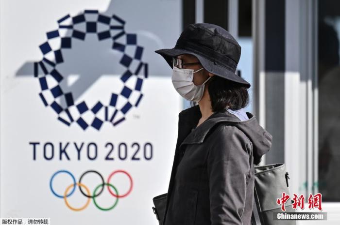 一名女士走过2020年东京奥运会海报。
