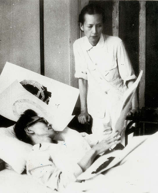 1950年梁思成在病床上与林徽因讨论国徽设计方案