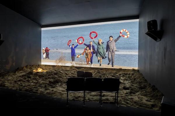 在展览现场“红霞”一层的影厅中，科幻长片《新星》放映于一片沙滩场景之上
