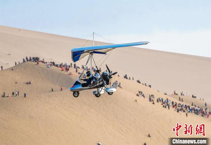图为游客乘坐滑翔机从空中鸟瞰大漠美景。　王斌银 摄