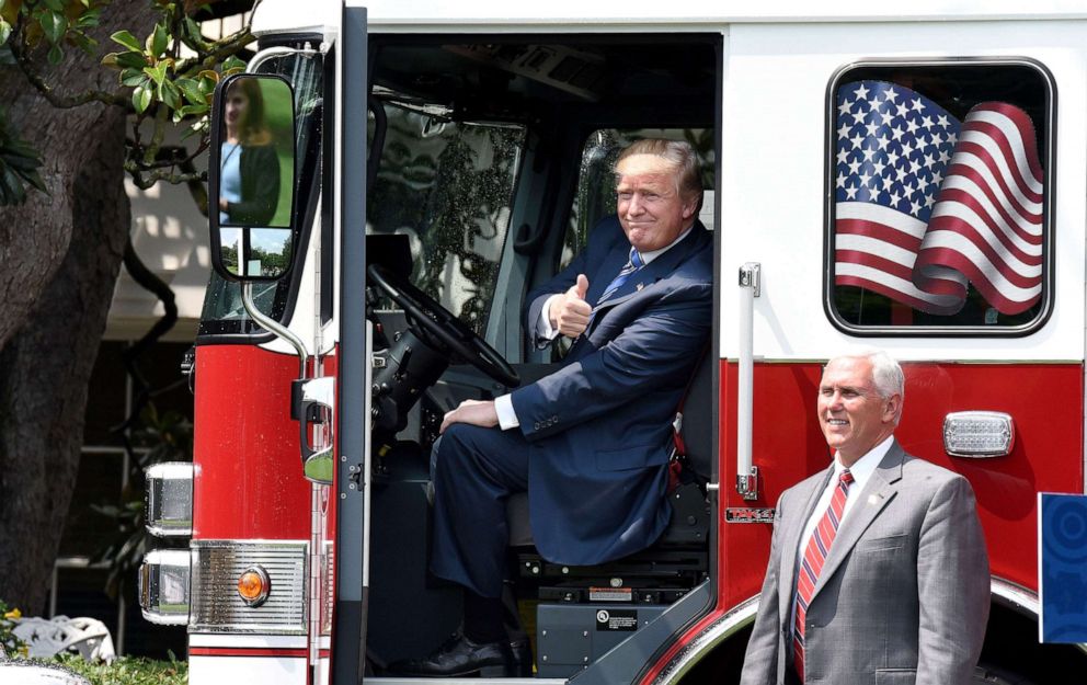 PHOTO: President Donald Trump gives the thumbs-up sitting inside a  fire truck as Vice President Mike Pence looks on during a 